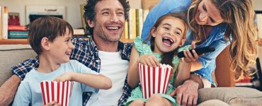 Dad and family laughing watching a movie