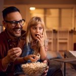 Father And Daughter Watch Movie On Laptop
