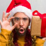 Man Holding Christmas Gifts And Santa Hat