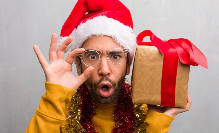 Man Holding Christmas Gifts And Santa Hat