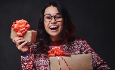 Woman Holding Christmas Gifts And Smilinig