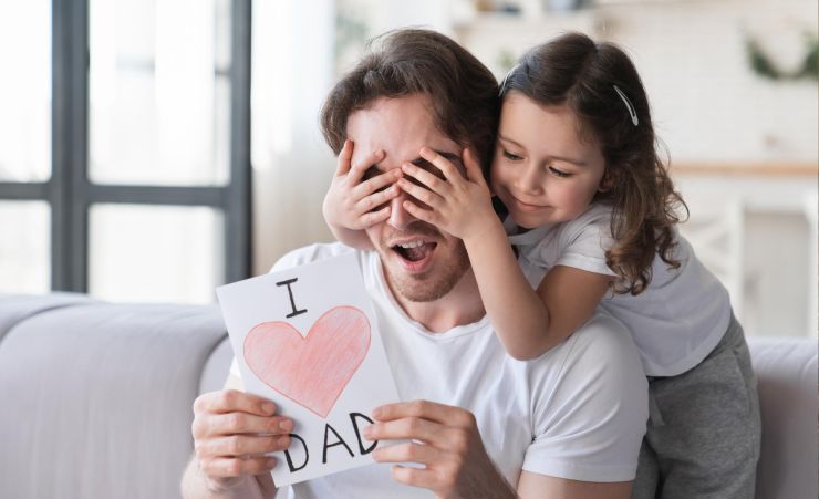 Daughter Giving Card To Dad