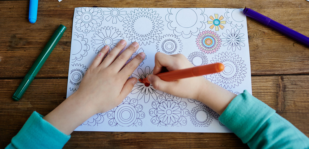 Kid Using A Colouring In Book