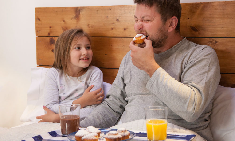 daughter serving dad breakfast in bed