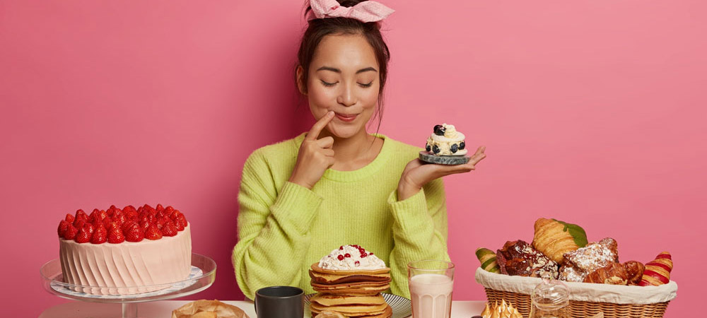 girl sitting with lots of desserts
