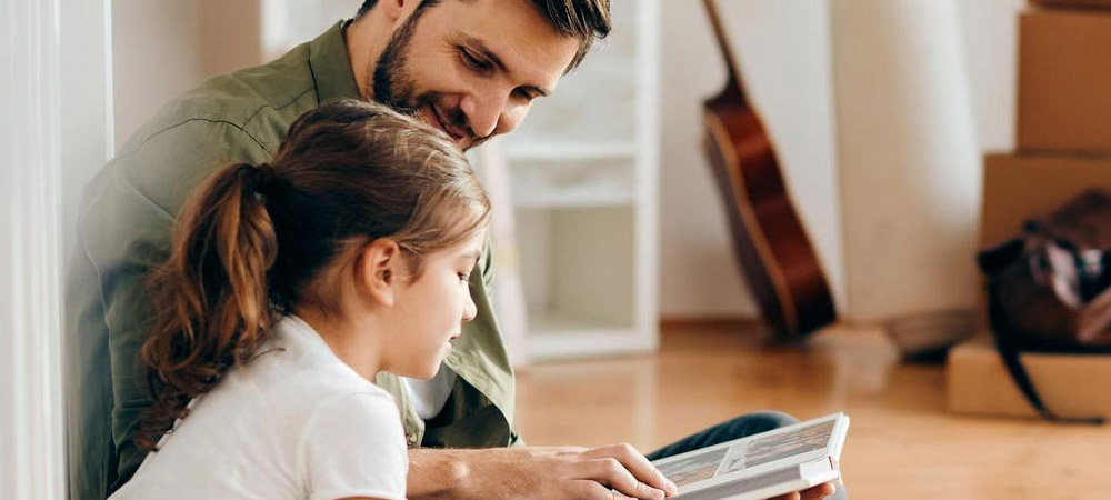 father and daughter looking at book